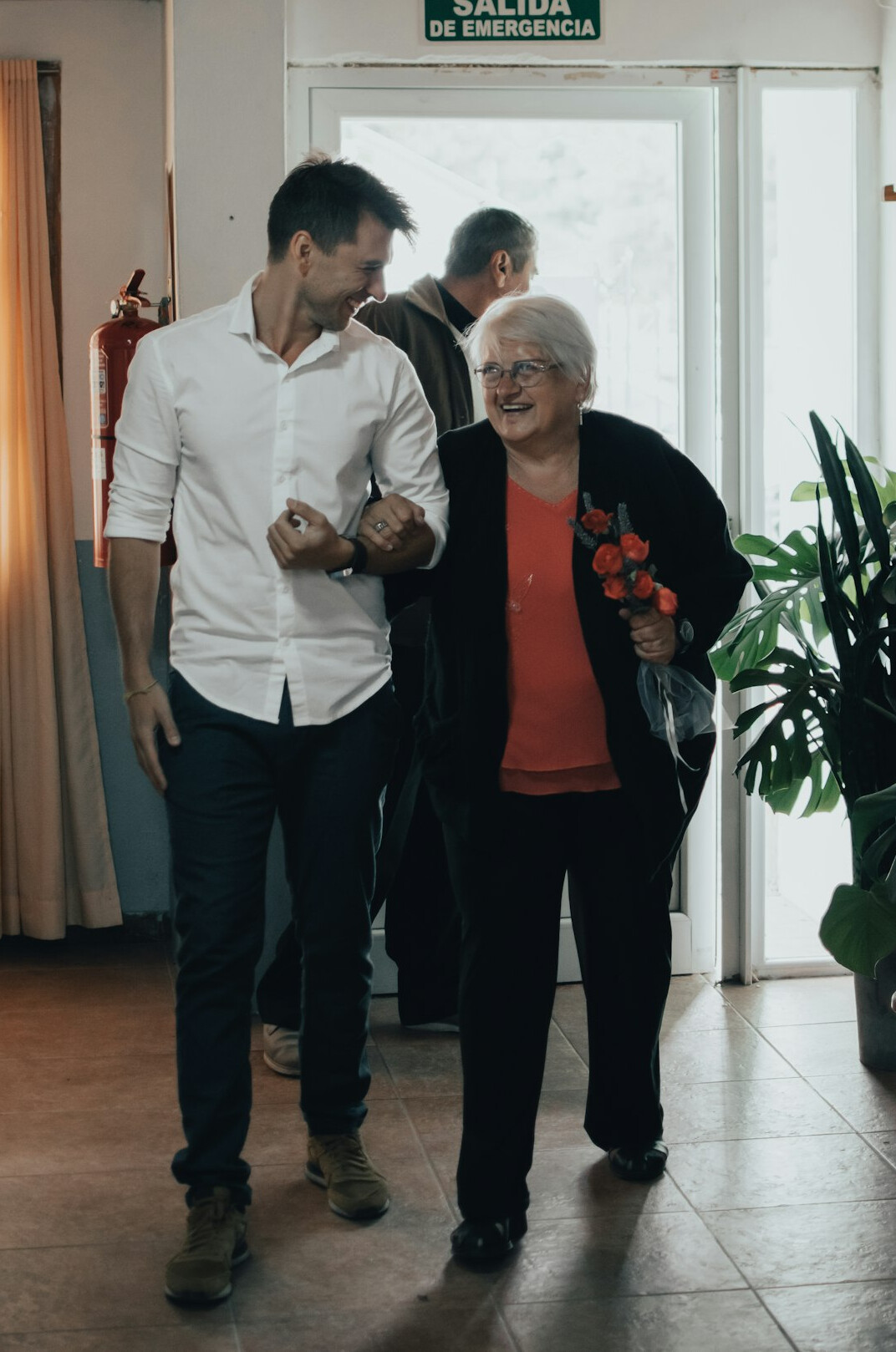 Friendly club coordinator welcoming a senior visitor at a bright reception desk