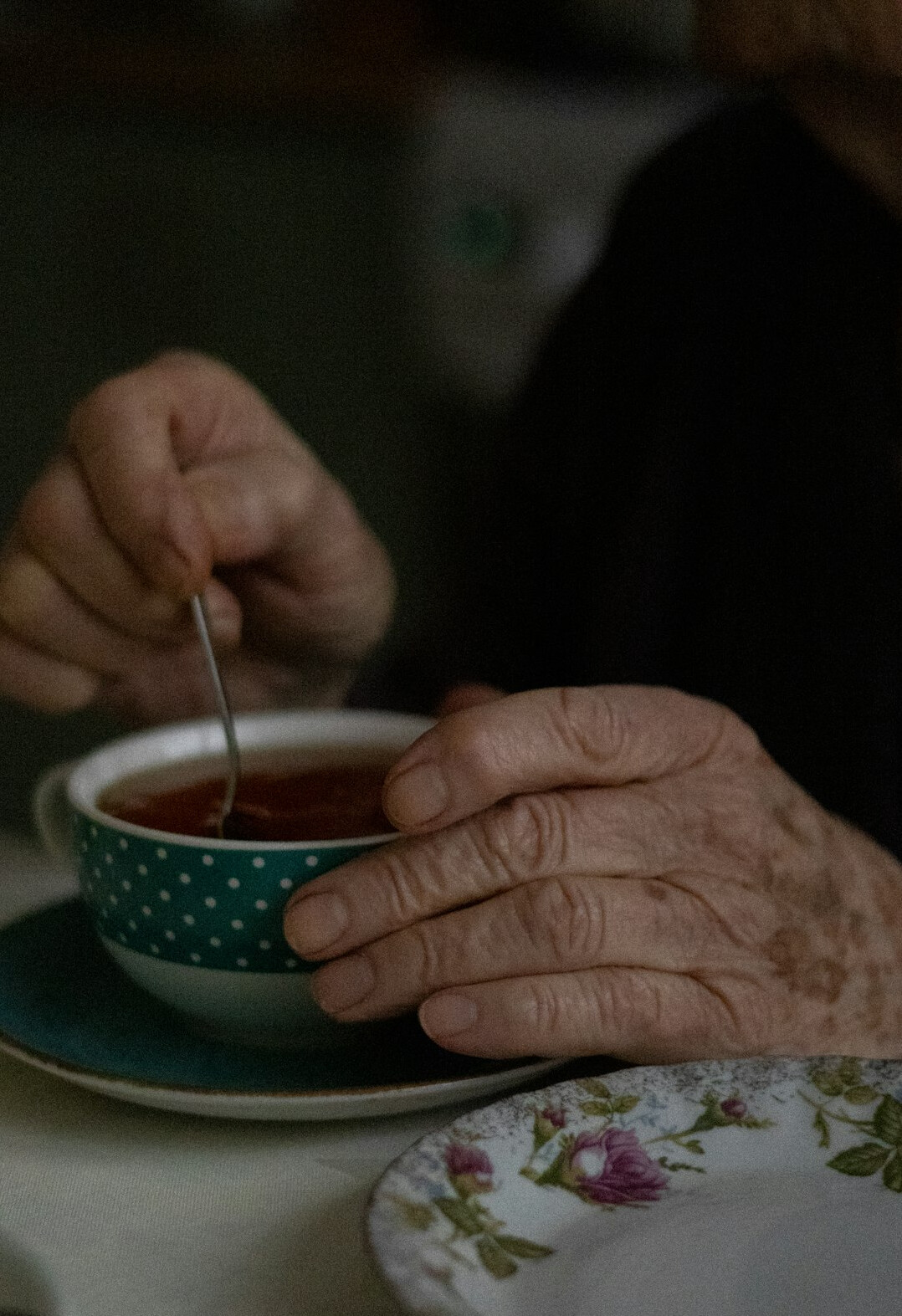 Senior friends chatting over tea and cake in a cozy club lounge