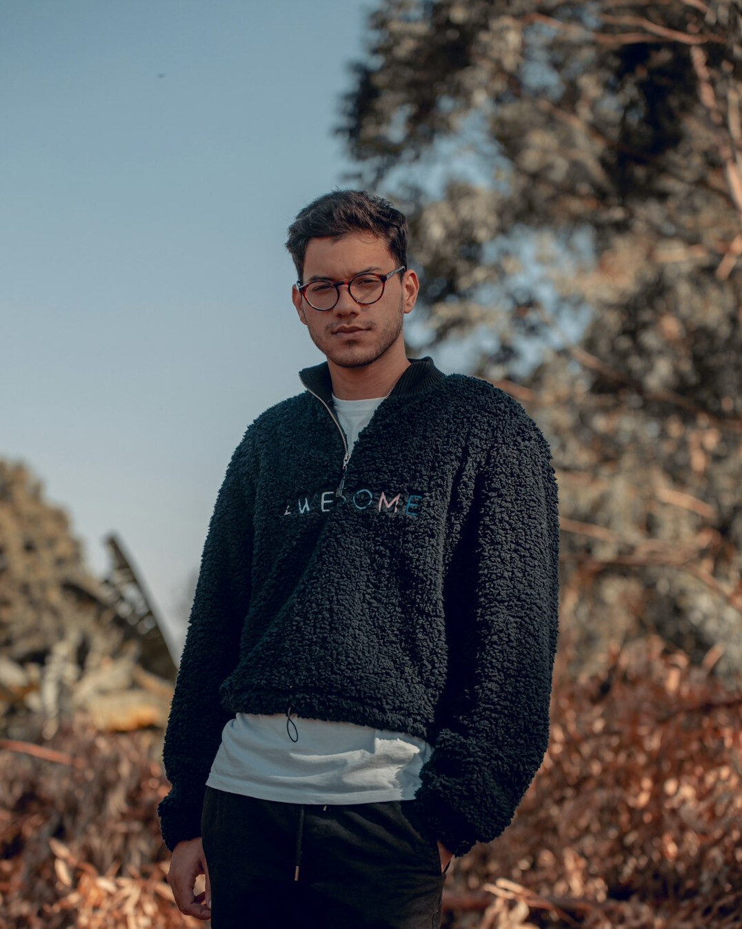 Portrait of a smiling middle-aged man with glasses in a cozy sweater