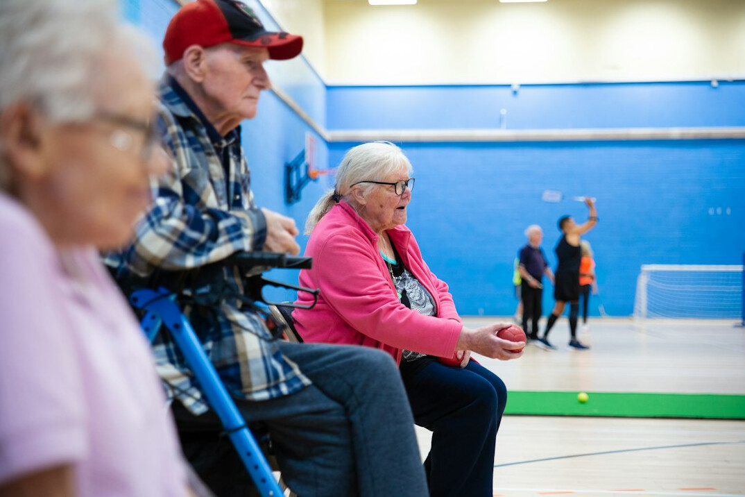 group of elderly people talking in community center