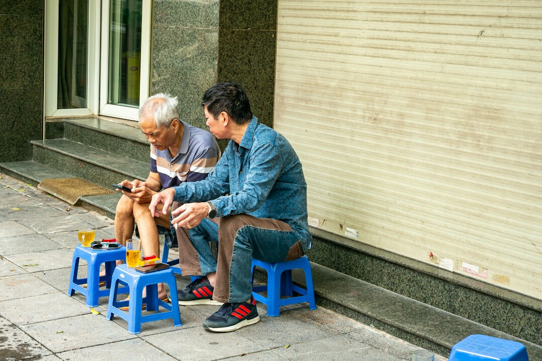 Senior man learning to use a tablet with help from a patient volunteer